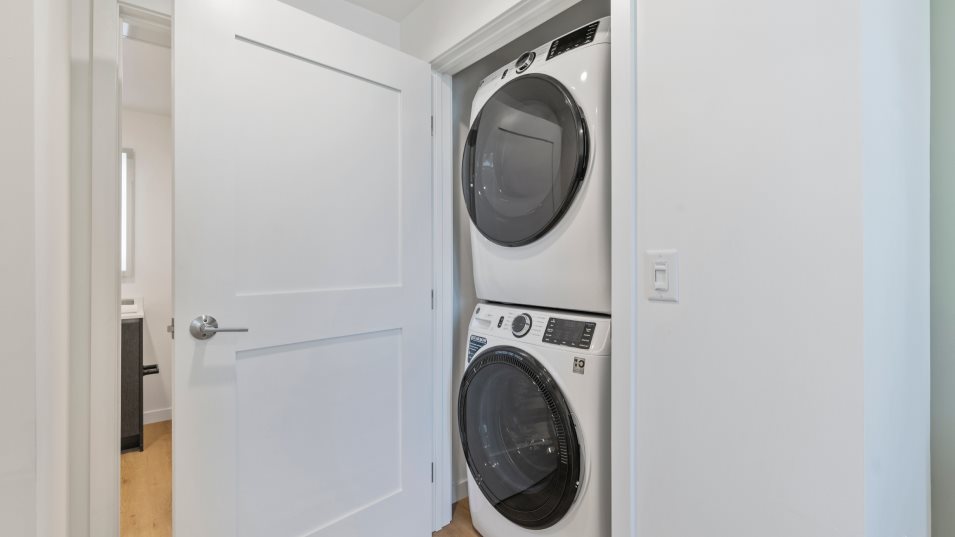 Laundry area with door and stacked washer dryer