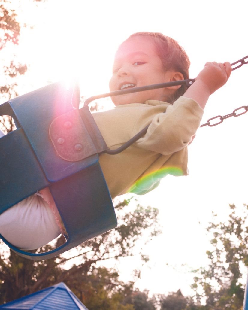 Toddler girl swinging on swing