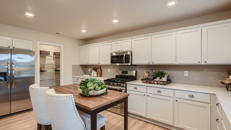 Kitchen island with seating surrounded by cabinetry