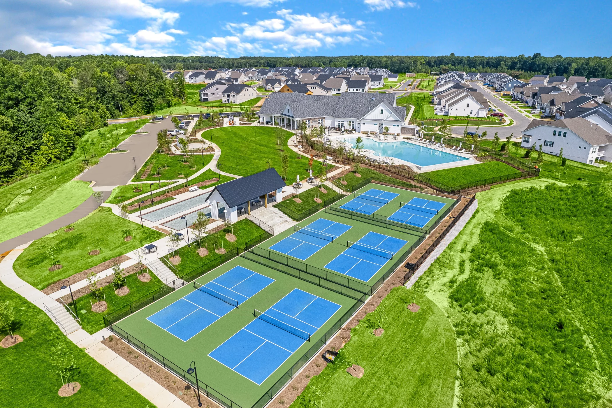 IMAGE: Photo of pickleball courts, bocce ball courts, pool and clubhouse at St. Charles Parklands 55+ Community