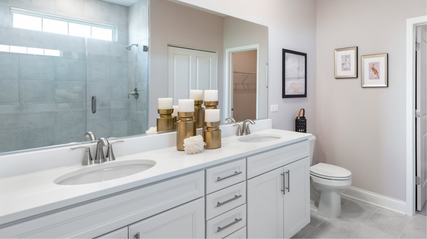 Spacious vanity with quartz countertops and Moen® brushed nickel faucets in the owner’s suite bathroom